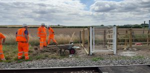 Men in orange clothing working on new pedestrian crossing on the railway 